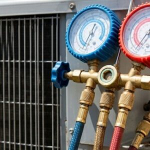 professional HVAC gauge manifold with red and blue dials and hoses