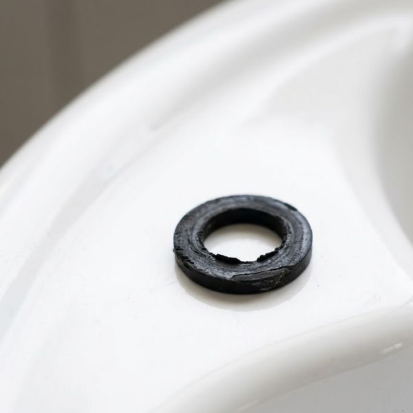 a small, worn black rubber plumbing washer.