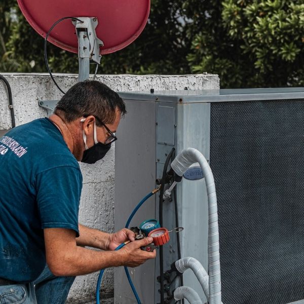 HVAC technician checking AC leak