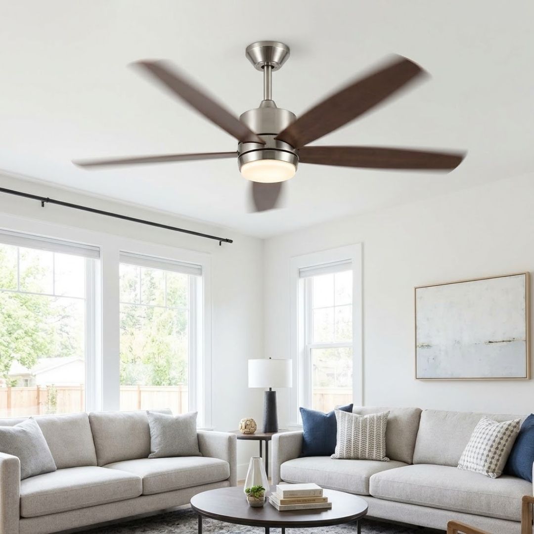 A modern, dark-wood residential ceiling fan with an integrated light fixture spins in a bright, sunlit living room.